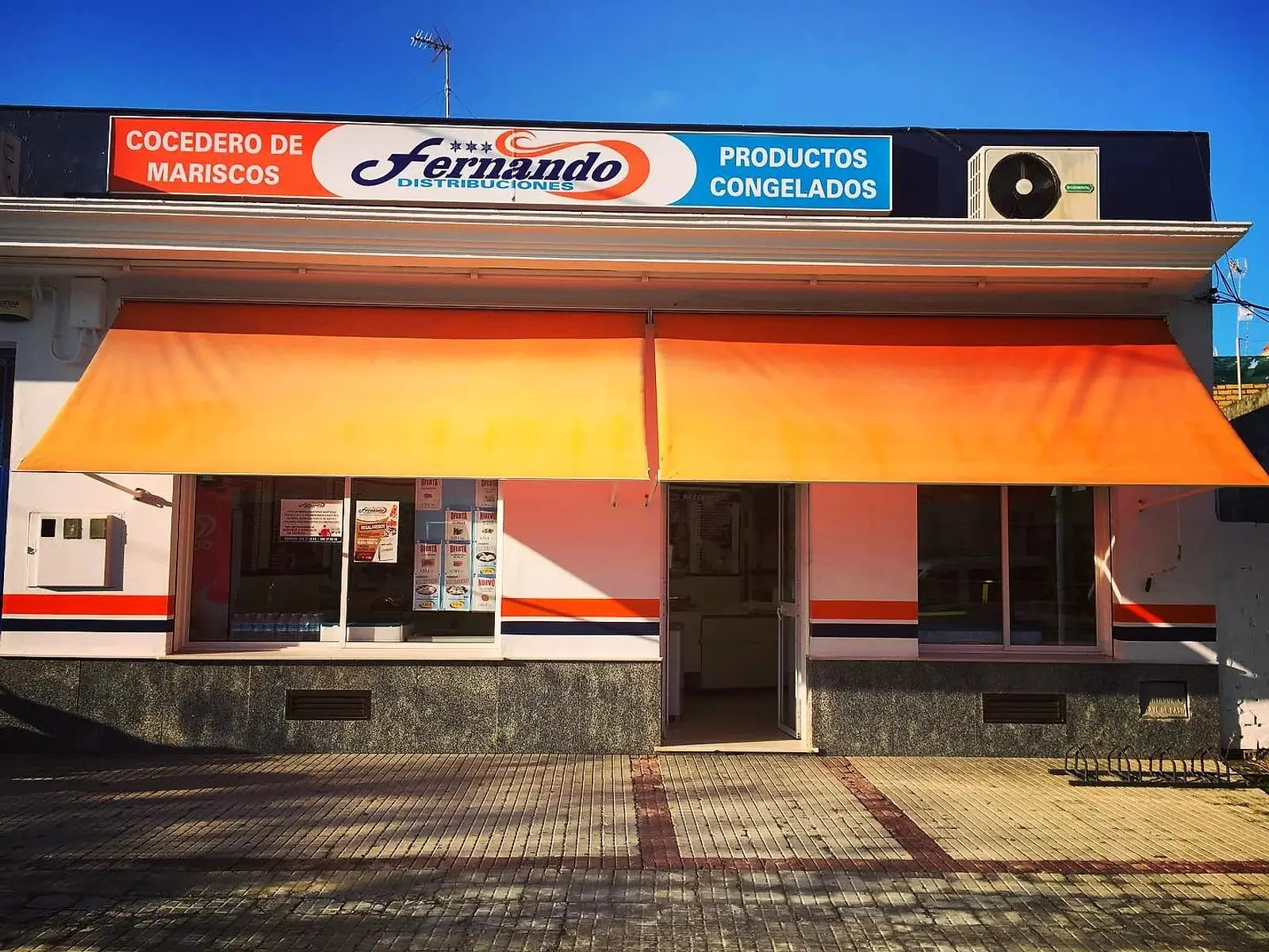 Fachada de la tienda de Congelados Fernando en la Avenida de Rota, con el toldo naranja