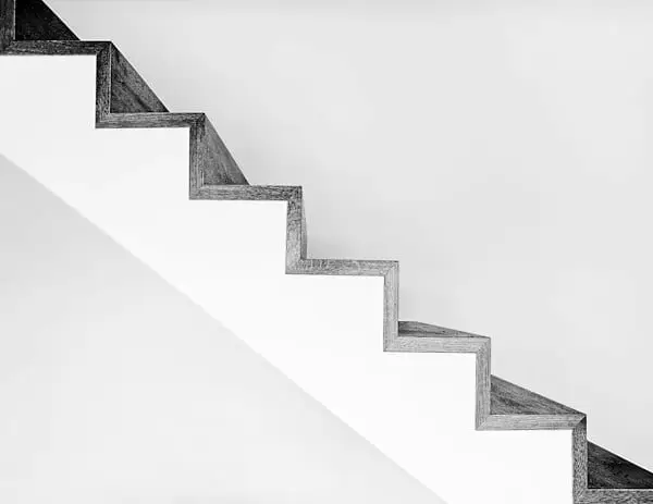 Una escalera blanca de perfil, escalón a escalón